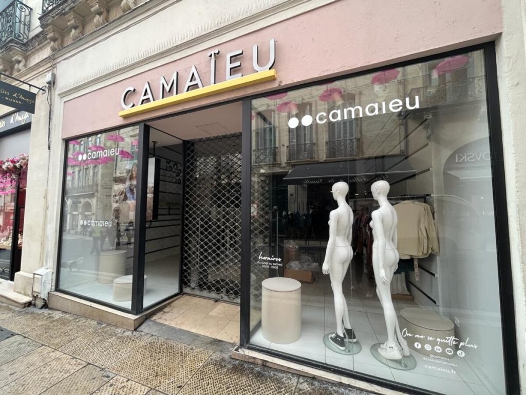 Boutique Camailleu avec des vitrines, mannequins en vitrine et décorations colorées.